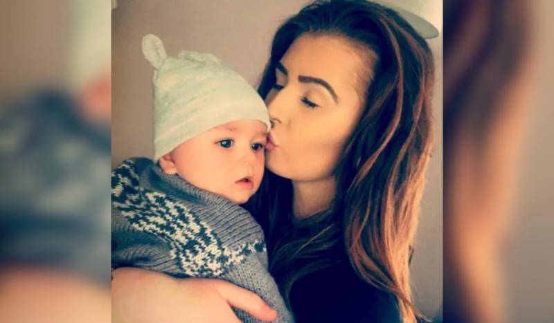 Mulher branca beijando em cabea de beb usando touca azul listrada
