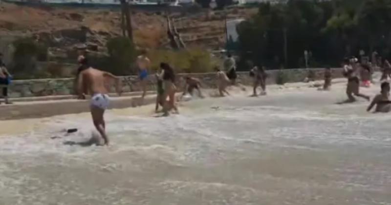 Banhistas correndo de onda na Grcia