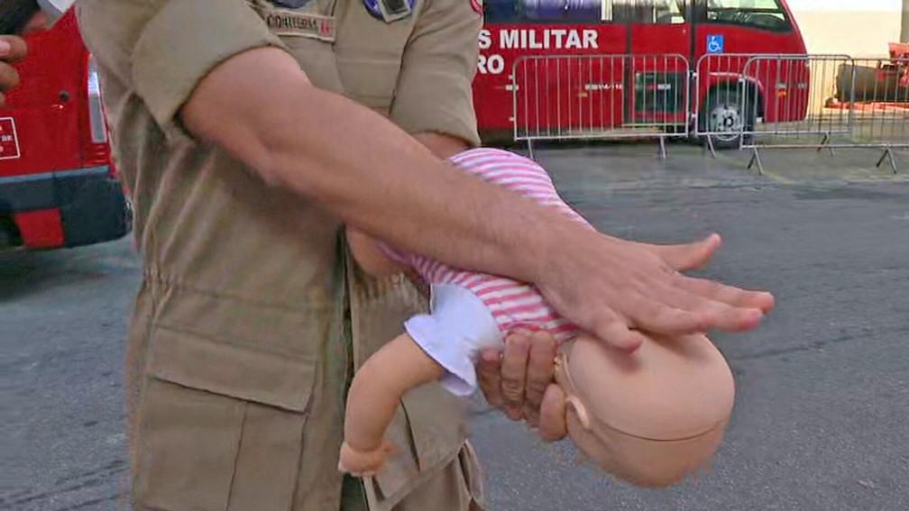 Usando o punho da outra mo e deixando os dedos estendidos aplique cinco palmadas no meio das costas da criana Foto ReproduoTV Globo