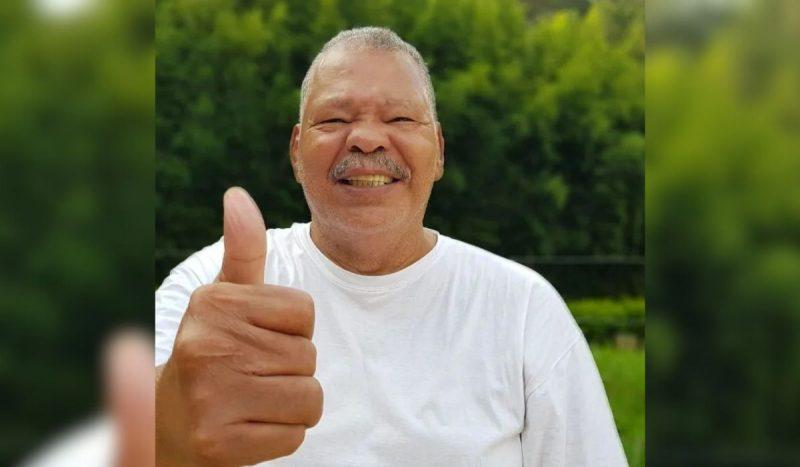 Maguila morreu aps ETC - homem negro gordo usando camiseta branca bsica sorrindo e fazendo joinha com o dedo